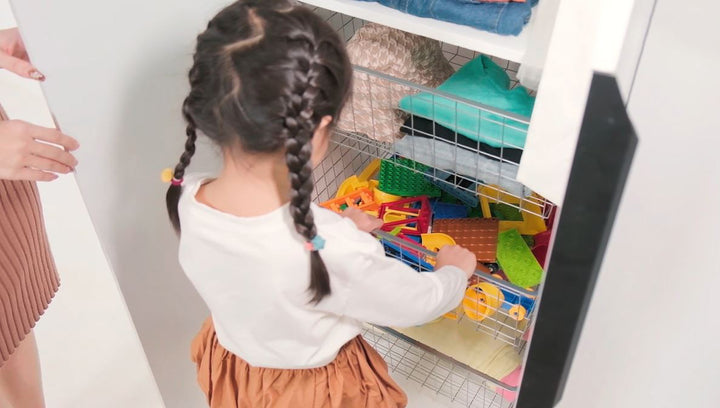 Hands retrieving snacks from an open BIANCA Low Storage Cabinet drawer